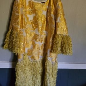 A Gold dress with feather cuffs and Hem..